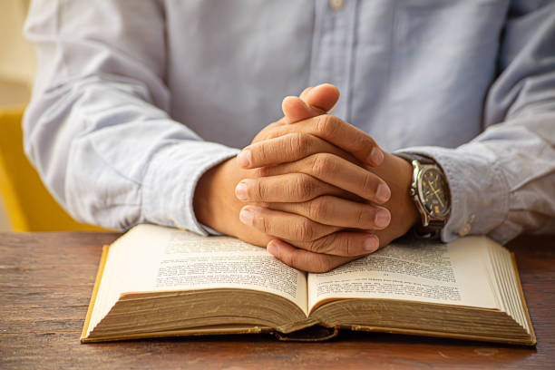 istock Christian man hand praying to god with the bible. 2017830862