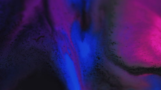Ink blend. Paint water mix. Defocused glowing neon blue purple pink black color acrylic fluid wave flow motion particles texture art abstract background.
