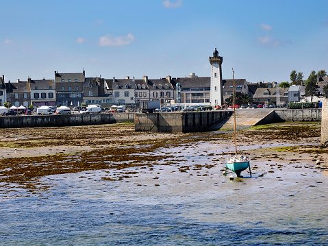 Port and lighthouse of Roscoff in low tide, a commune in the Finistère département of Brittany in northwestern France