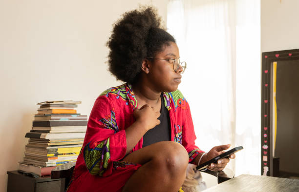 istock afro woman concentrating on using her mobile phone while looking to the side 2017853970
