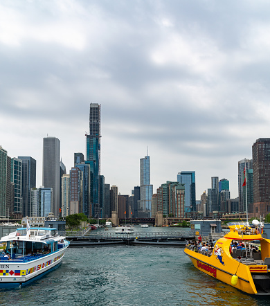 Chicago, Illinois - June 30, 2019: Tour boats wait at the entrance to the Chicago Harbor Lock to transit from Lake Michigan to the Chicago River.