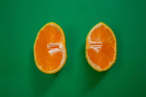 Sliced tangerine isolated on a green background. Top view, copy space.