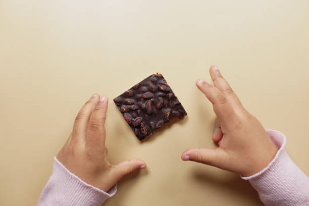 istock top view of child hand reaching for dark chocolate 2017888714