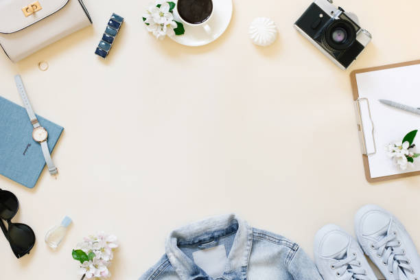 istock Planning a summer trip. A tablet with a blank sheet of paper, a retro camera, white apple blossoms, a watch, women's clothing and a cup of coffee on a beige background with a copy space. The workplace of a travel blogger 2017919564