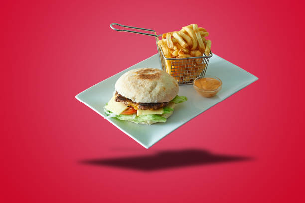 Floating plate with Burger and french fries  on red gradient background