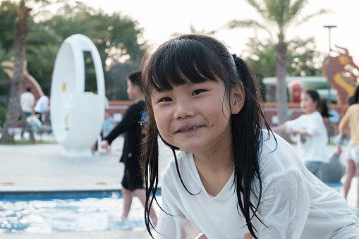 Little girl smiling at the camera in the swimming pool