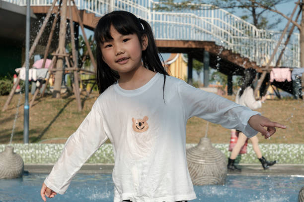 Happy kid girl having fun in swimming pool
