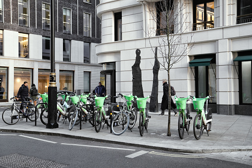 Curzon Street, London, England,  the United Kingdom - 01st February 2024: Bicycle-sharing system in the Mayfair area. several green pedal bikes on the street in the daytime within the Mayfair district of London. London's bike-sharing rental bicycles.