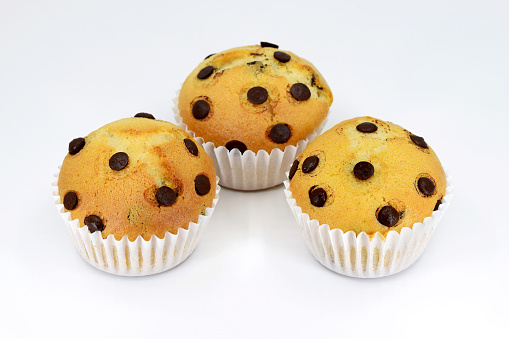 Delicious homemade muffins with chocolate chips, white background