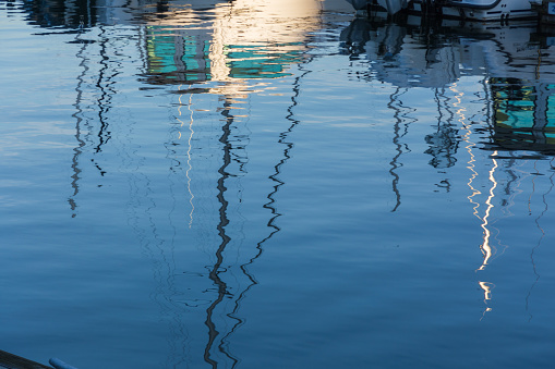 A tight focus on the masts of sailboats in the water of a Vancouver marina.