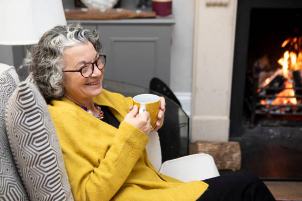 istock Smiling mature woman sitting on a sofa with a coffee 2018021887
