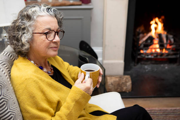 istock Thoughtful mature woman sitting on a sofa with a coffee 2018022351