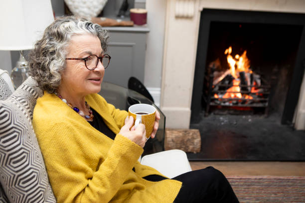 istock Mature woman sitting on a sofa with a coffee 2018022910