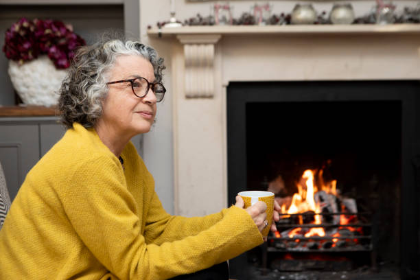 Mature woman sitting on a sofa with a coffee