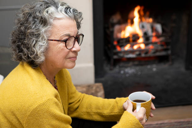 istock Mature woman sitting on a sofa with a coffee 2018024992