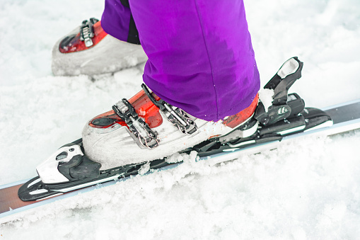 The athlete skier demonstrates a set of skis and boots on the leg. 2019