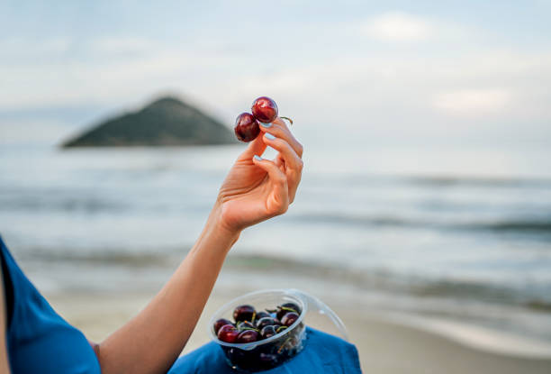 Juicy cherries in the female hand at the beach