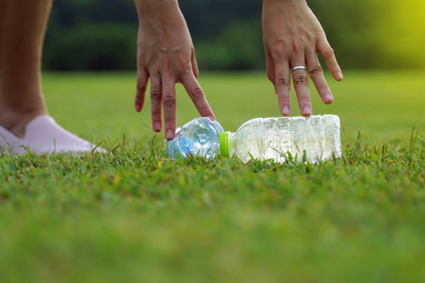 istock People help pick up trash from plastic bottles left on the lawn. 2018045587