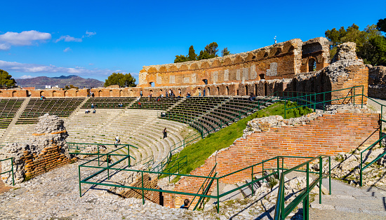 Taormina, Sicily, Italy - February 15, 2023: Greek and Roman period Teatro antico Ancient Theatre with cavea seating auditorium in Taormina at Ioanian sea shore of Sicily