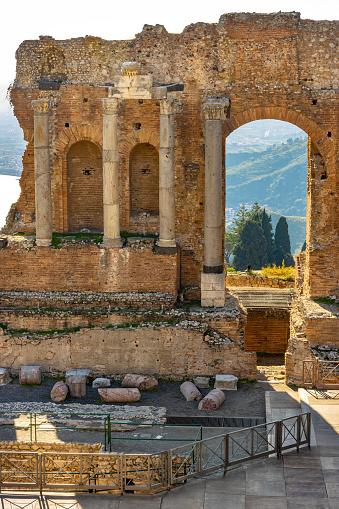 Taormina, Sicily, Italy - February 15, 2023: Greek and Roman period Teatro antico Ancient Theatre with stage and arches colonnade in Taormina at Ioanian sea shore of Sicily