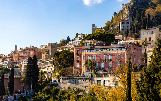 Taormina, Sicily, Italy - February 15, 2023: Panoramic view of Taormina historic old town with residential estates over Ionian sea shore in Messina region of Sicily