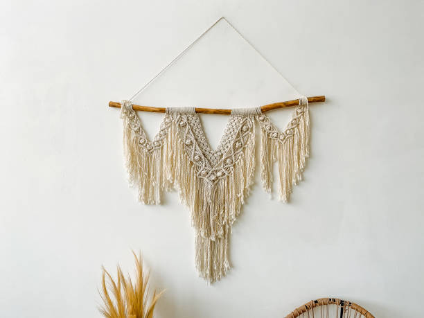 istock White wall adorned with macrame wall hanging, twig, plant, art, jewellery, wood, font; rectangular metal frame, houseplant event. 2018075912