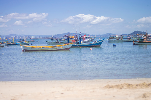 Penha-sc,brazil-February 10,2024 : people on a beach in Santa Catarina with sea and many boats in the background..