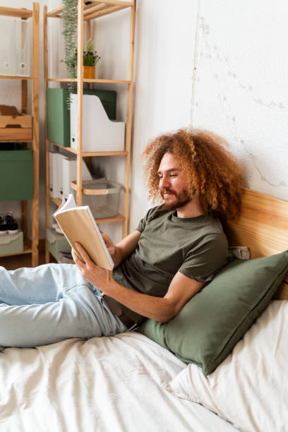 istock Man Engaged in Reading a Book at Home 2018086432