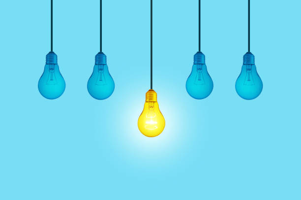 Blue light bulbs with glowing one yellow different light bulb idea hanging on blue background.  Think creatively concept. New Creative Idea. Brainstorm
