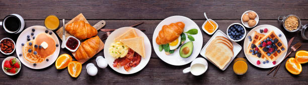 istock Breakfast or brunch table scene on a dark wood banner background. Top view. 2018089054