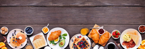 istock Breakfast or brunch bottom border on a dark wood banner background. Top down view. 2018089056