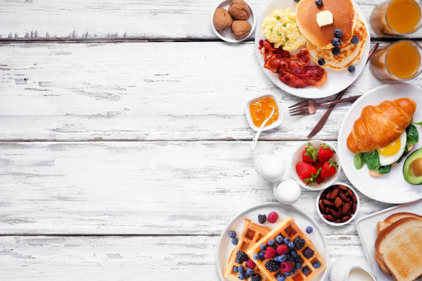 istock Breakfast or brunch side border on a white wood background. Top down view. 2018089570