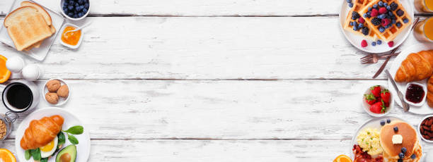 istock Breakfast or brunch double border on a white wood banner background. Above view. 2018089573