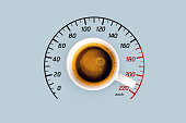 Coffee and energy boost, creative idea. Caffeine and top speed, concept. Americano cup and speedometer