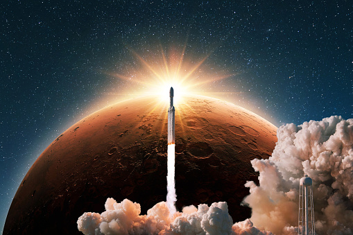 Space rocket with smoke and blast successfully launching to the red planet mars with sun rays. New spaceship lift off into starry space at sunset. Start of a space mission. Rocket, concept
