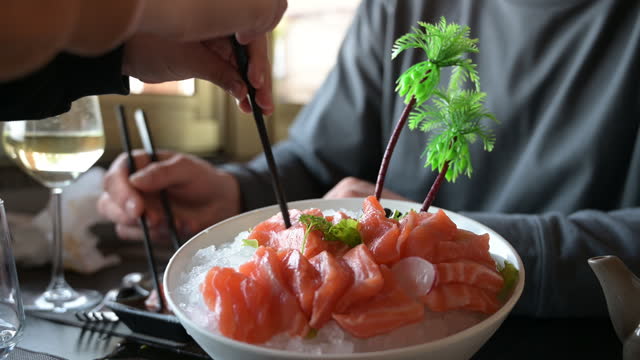 eating raw sashimi in a restaurant.