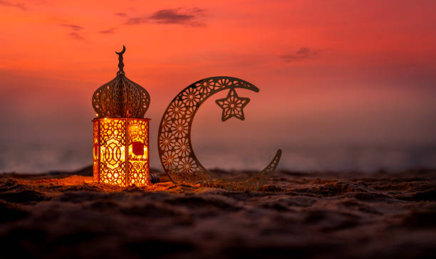 istock Traditional lantern lamp with crescent moon on the beach at sunset 2018100336