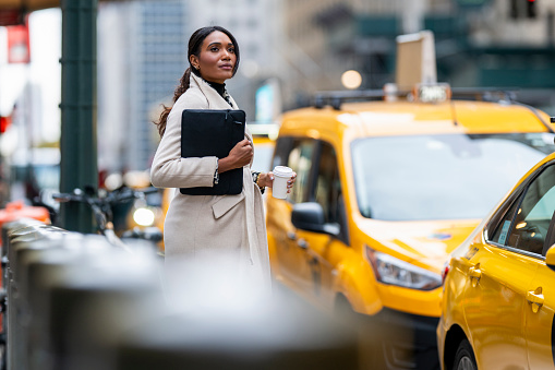 A beautiful black woman seen standing on the street of Manhattan before entering the taxi