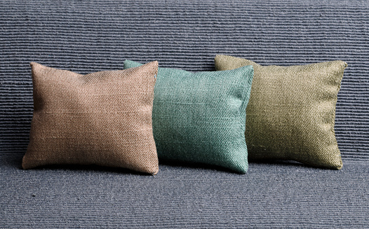 Subtle shades green,gray and brown cozy cushions on a sofa