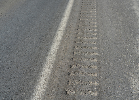 Rumble strips and white line on side of road.  Safety feature to keep drivers alert.