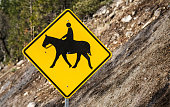 Horse Crossing Sign on Side of Highway in Rural Area
