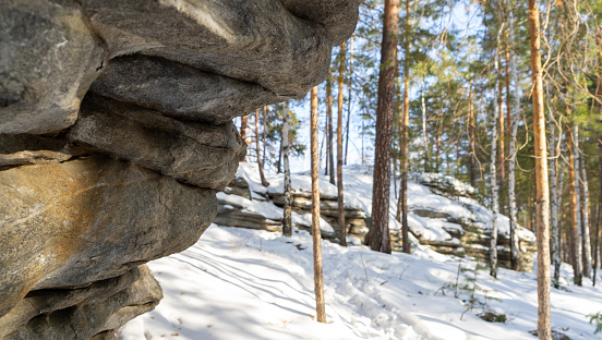 Rock Isetskaya wall next to Mount Motaiha. Long rocky ridge. Iset village, Sverdlovsk region, Ural, Russia. Tourist attractions. Hiking in winter.