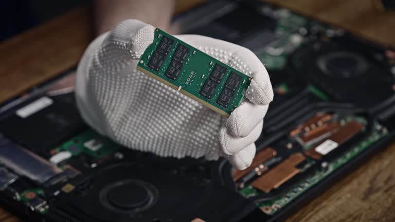 Person holding a ram stick in front of a laptop with woolen texture