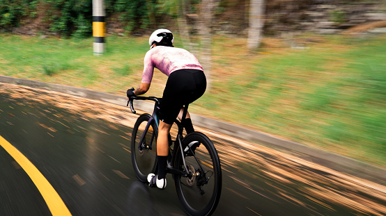 cyclist riding down a hill very fast.