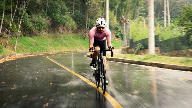 Male cyclist training at high speeds and riding down a hill. Photo in motion with the background in movement