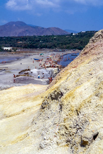 Vulcano Island, Aeolian Islands, Sicily, Italy - August 10, 1980: view of the beach of the island of Vulcano with yellow sulphurous rocks in the foreground, in the Aeolian Islands