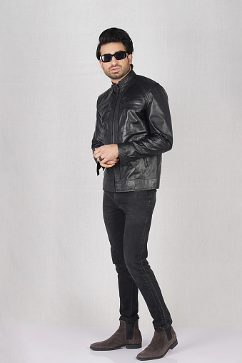 Pakistani Male Model posing in black leather jacket and black top with jeans and long high boots