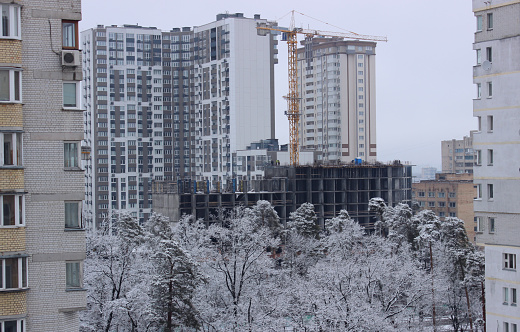 Construction  site of a multi-apartment high-rise residential complex near a green park
