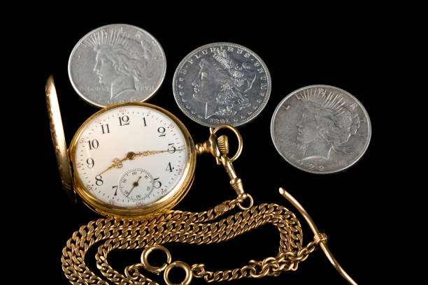 istock Antique pocket watch with three antique silver dollars 2018257917