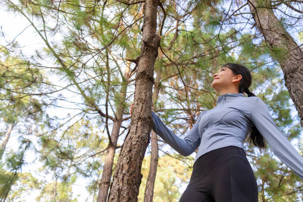 istock Young woman admiring the tree she embraces 2018267266